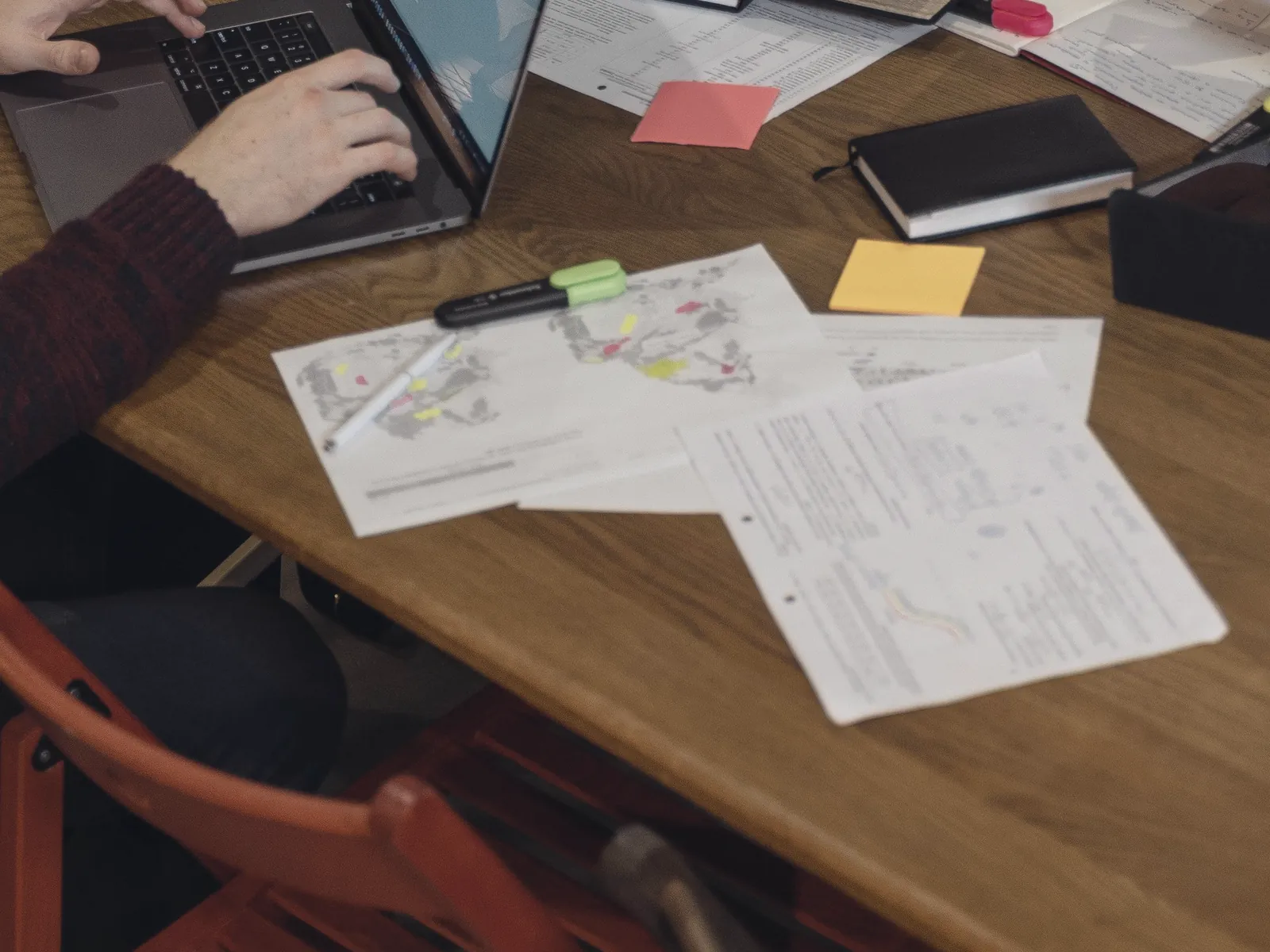 Table de travail avec ordinateur portable, notes et documents