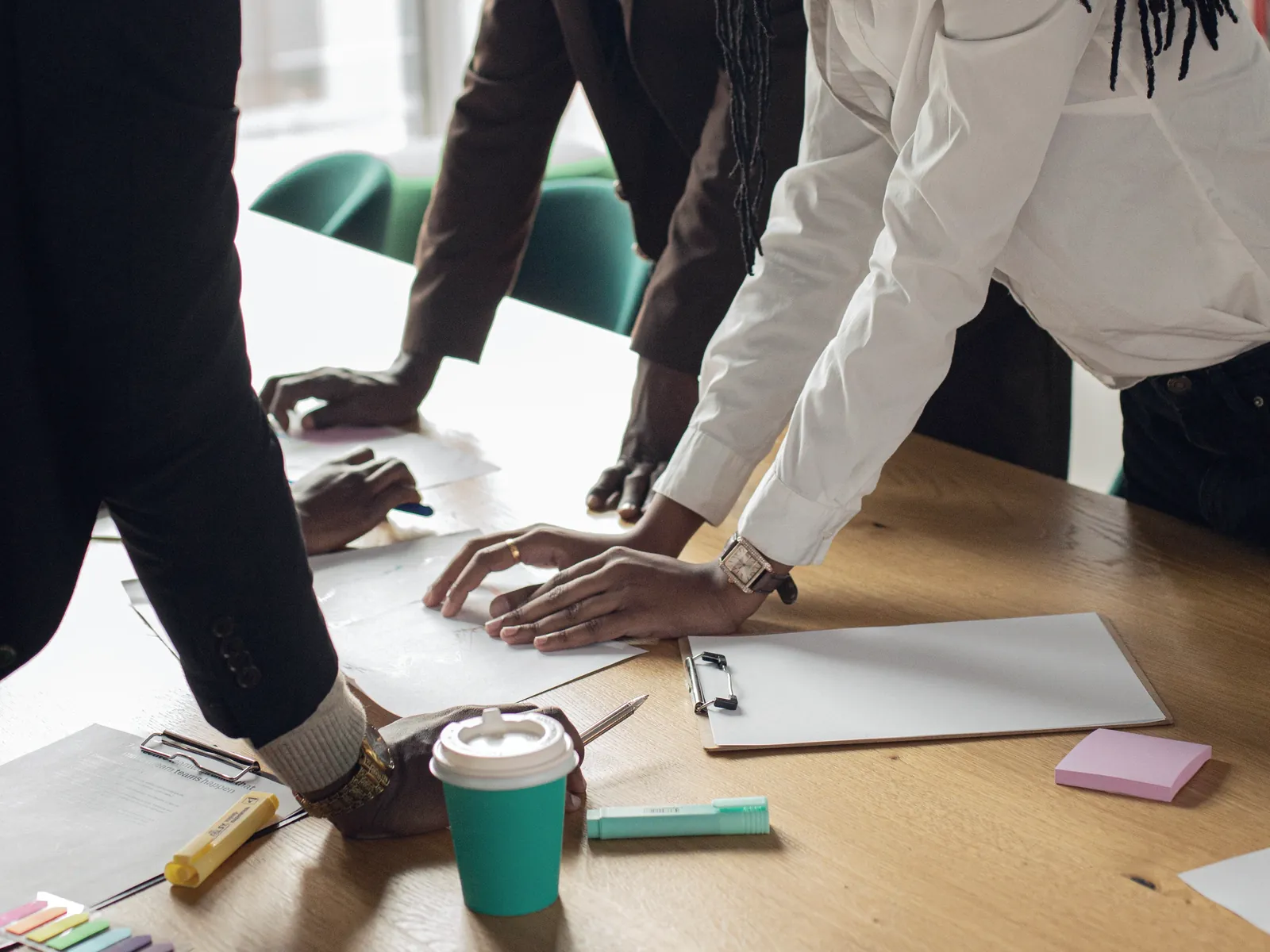 Mains posées sur des documents de travail autour d’une table
